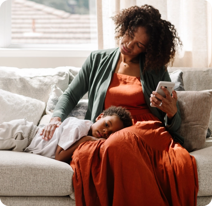 Mom on couch using Included Health app for her child.